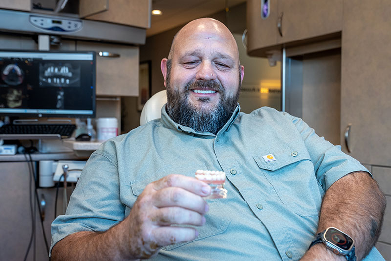 patient holding onto a dental implant model within the dental center