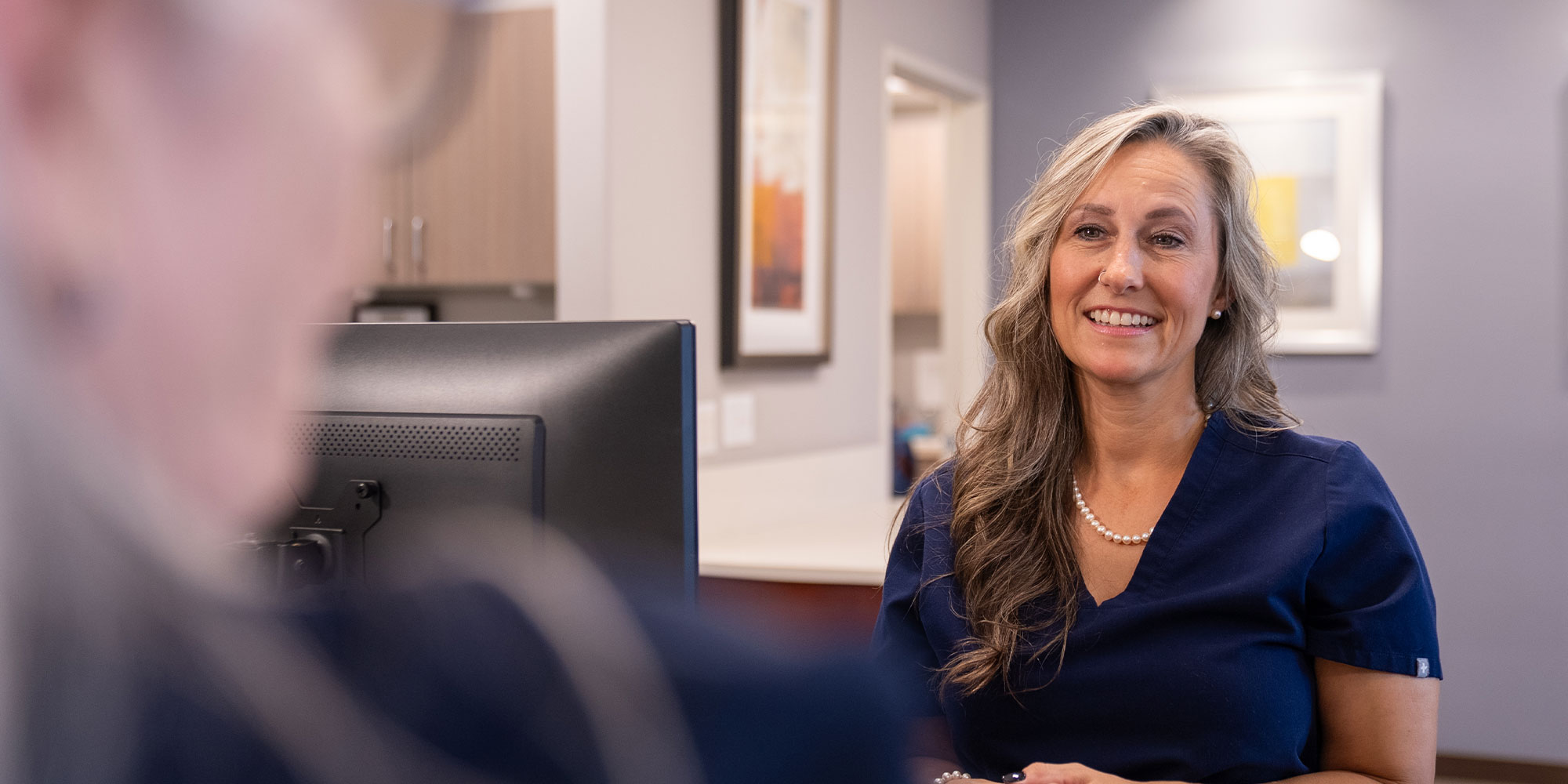 staff member helping patient at the front desk