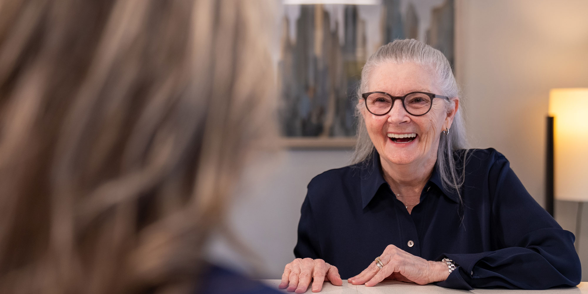 patient smiling and laughing while being helped at the front desk of the dental center