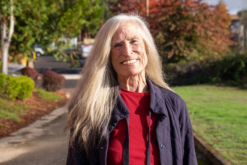 headshot of patient smiling brightly after their dental implant treatment outside